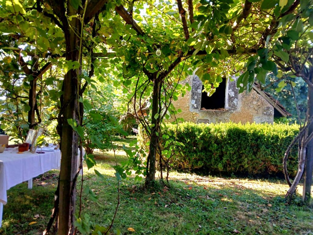 Une table pour accueillir un repas dans le jardin ombragé de la Thébaïde